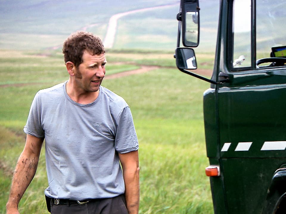Lukas Achermann steht neben seinem Lastwagen in Sibirien