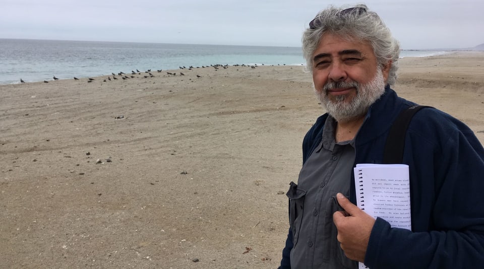 Ein Mann mit grauem Haar am Strand.