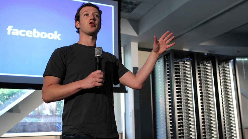 Facebook-Chef Mark Zuckerberg hält eine Rede, hinter ihm stehen Server.