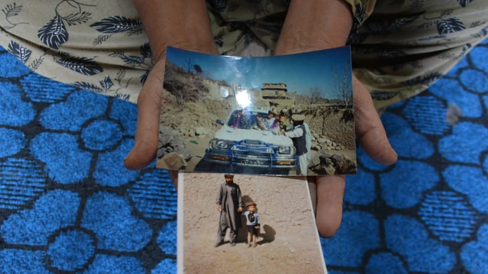 Ramanullah Borans Mutter zeigt Fotos von ihrem Mann, der 2002 bei einer Drohnenattacke ums Leben kam.