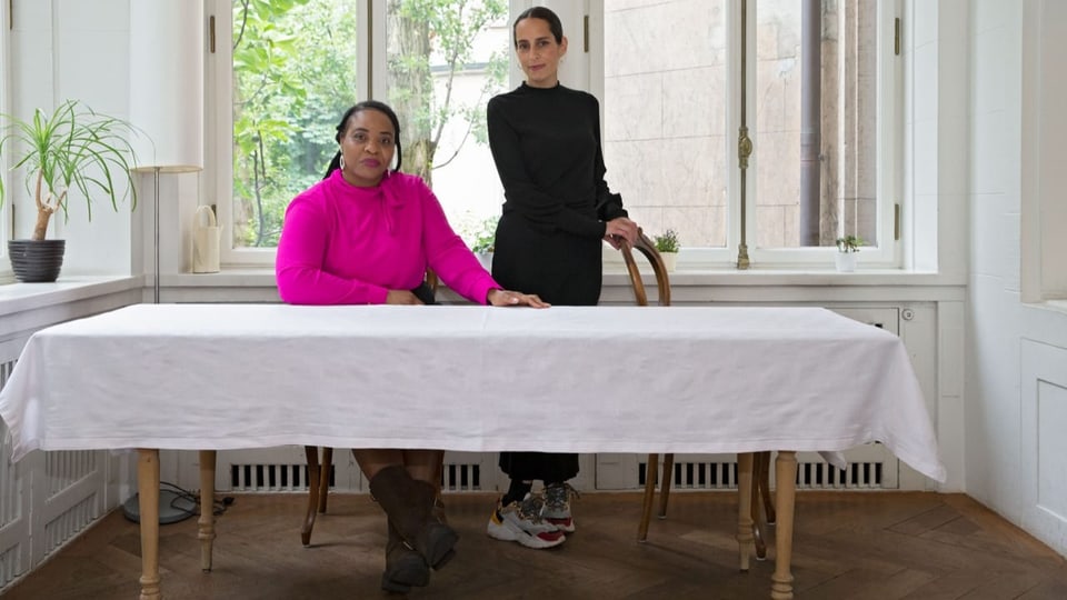 Zwei Frauen hinter einem Tisch.