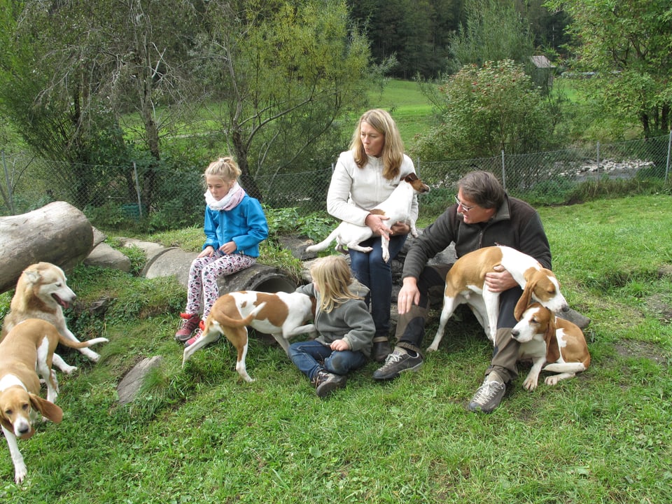 Zwei Kinder und zwei Erwachsene mit vier Hunden