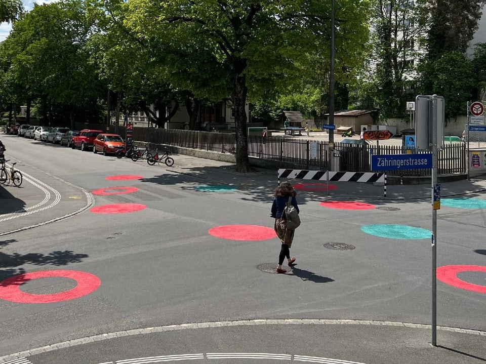 rote und grüne Punkte auf einer Quartierstrasse.