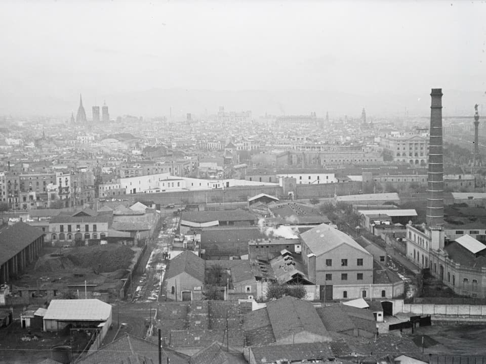 Blick auf eine Stadt, im Vordergrund ein Fabrikgelände.