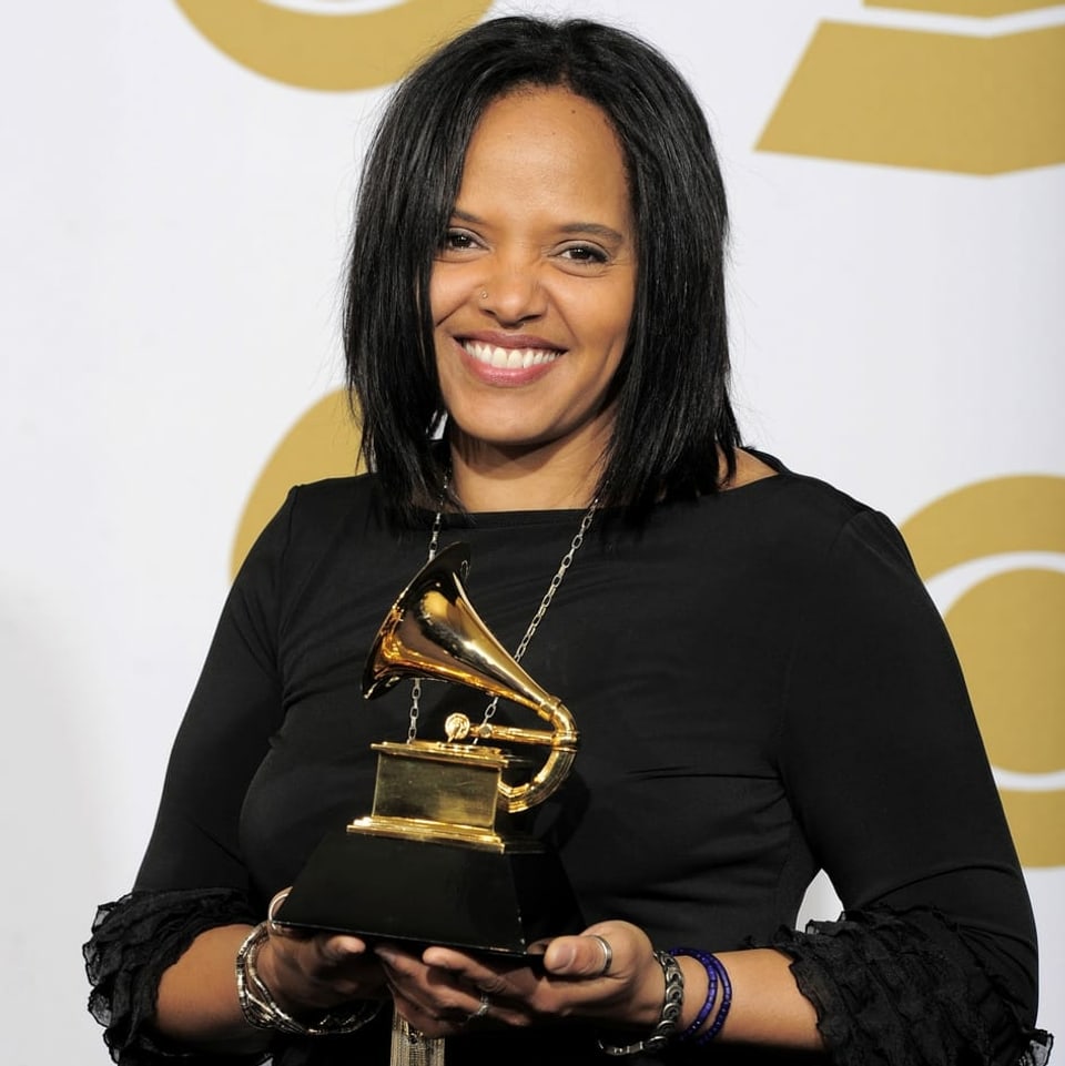 Die Schlagzeugerin Terri Lyne Carrington hält einen Grammy in den Händen.