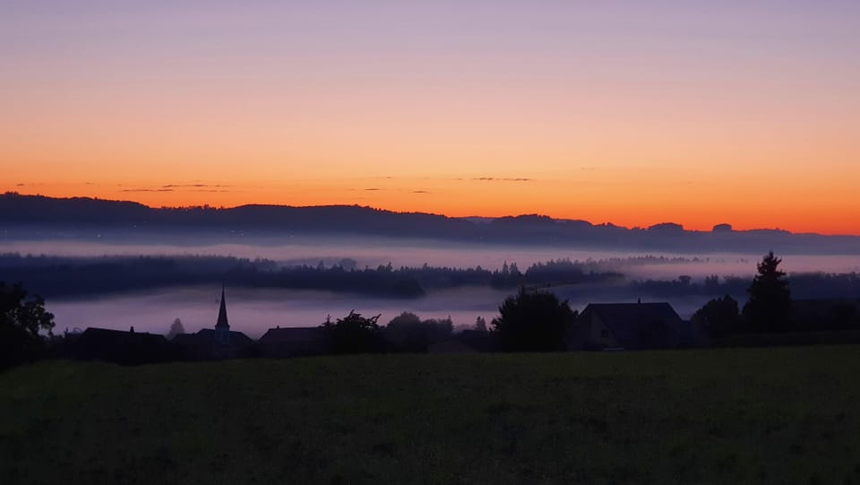 Schönes Morgenrot über den Hügelzügen und Bodennebelfelder im Thurtal.