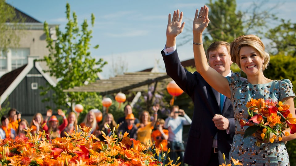 Willem-Alexander und Máxima von den Niederlanden winken ihren Anhängern zu.