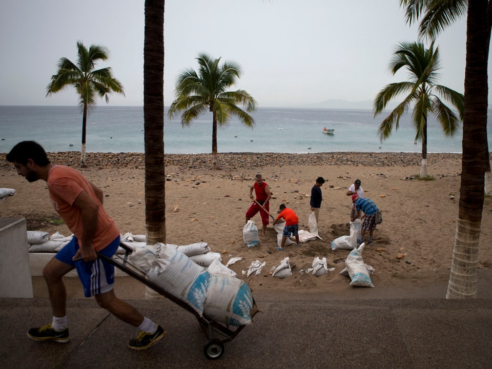 Eilig gefüllte Sandsäcke sollen in der Gefahrenregion an der Pazifikküste gegen meterhohe Wellen schützen. 