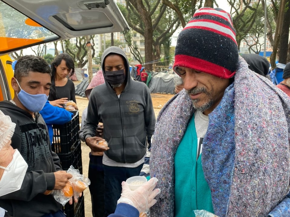 Ein Obdachloser erhält ein Maisbrot und eine Heisse Schokolade. Oft die einzige Mahlzeit am Tag.