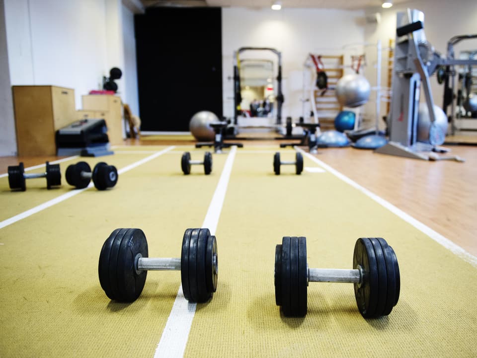 Ein Symbolbild aus einem Gym, zwei Hanteln liegen am Boden.
