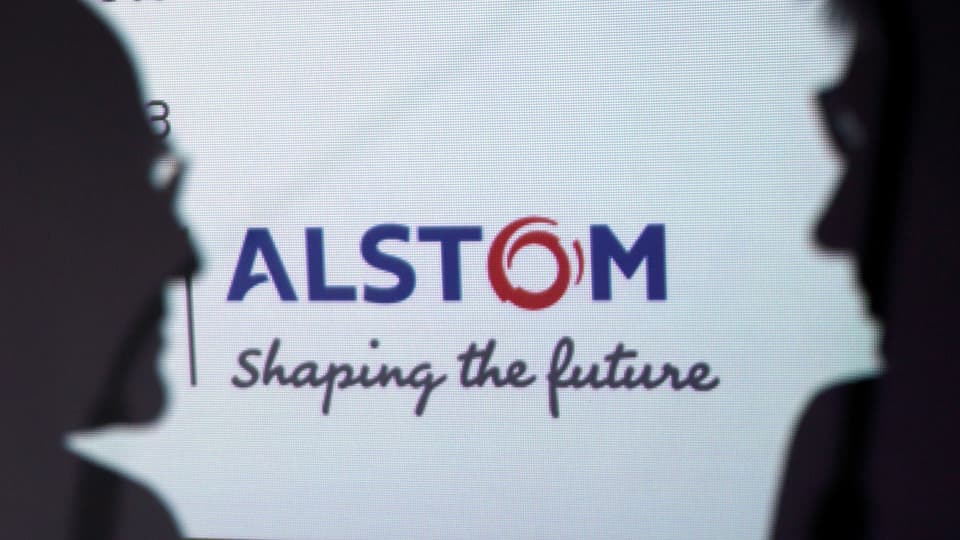 Silhouette von zwei Männern vor dem Alstom Logo