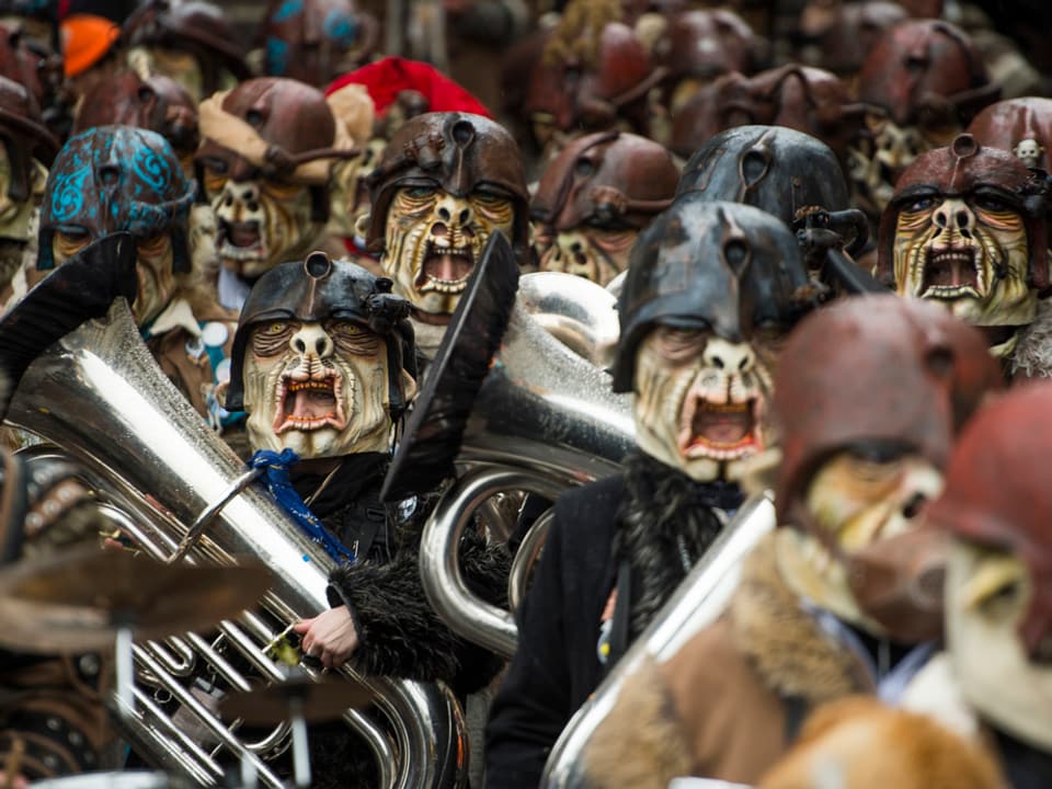 Guggenmusikformation mit grausligen Masken. 