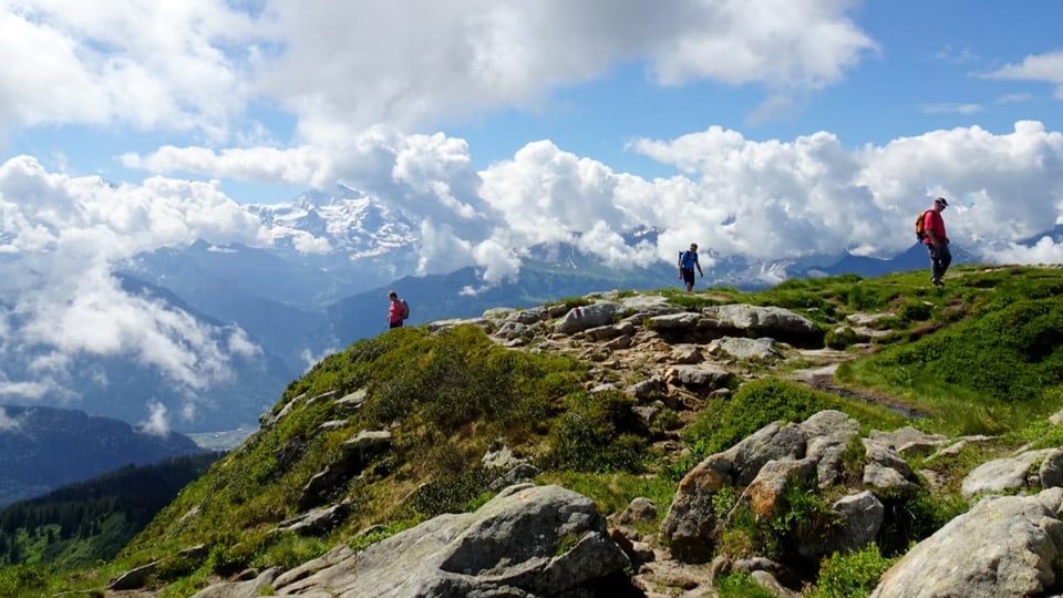 Wanderer in den Bergen mit Quellwolken