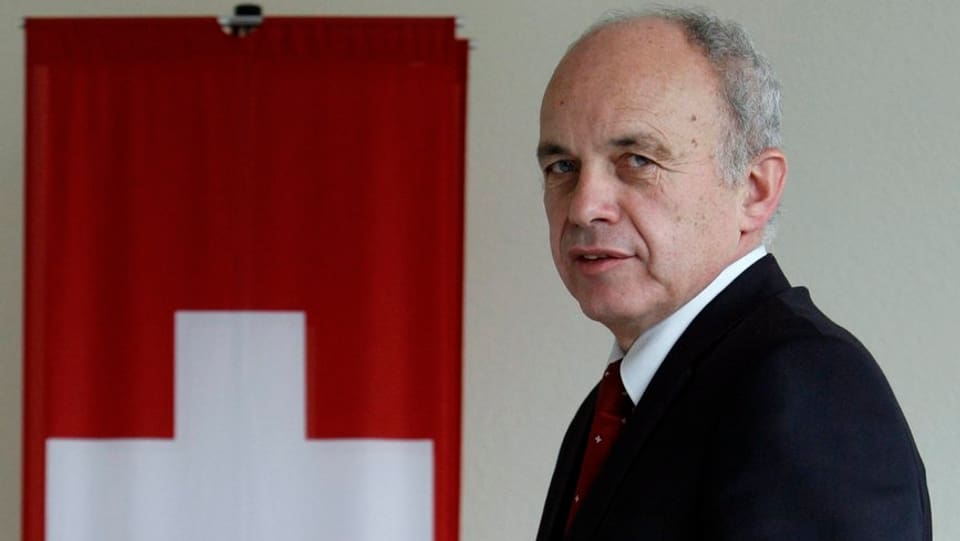 Bundespräsident Ueli Maurer neben einer Schweizer Fahne.