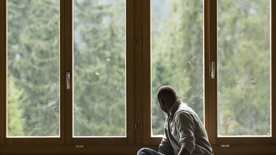 Asylsuchender schaut aus dem Fenster