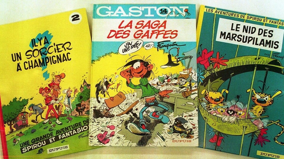 Drei Comicbände, einer Spirou und Fantasion, einer vom Marsupilami und einer von Gaston
