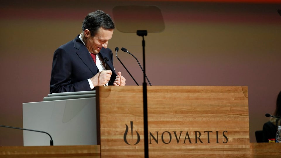 Daniel Vasella an einem Rednerpult. Er nestelt an seinem Veston rum.