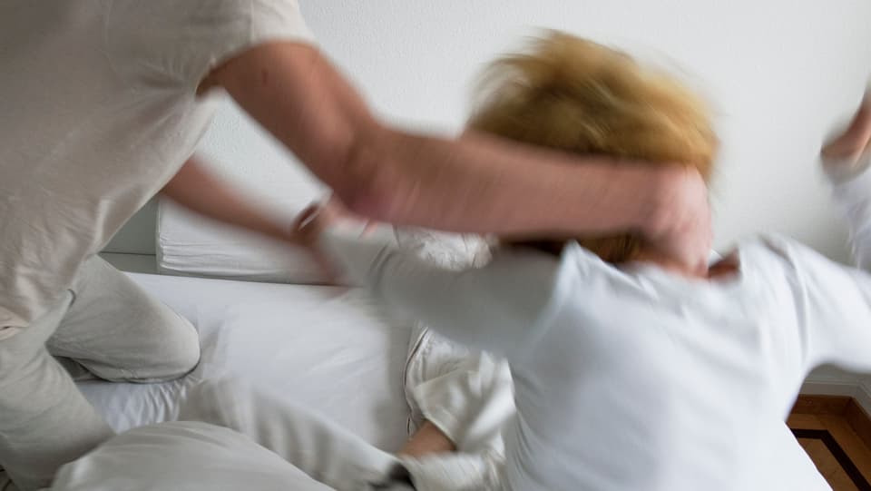 Eine Frau wird von ihrem Partner attackiert. 