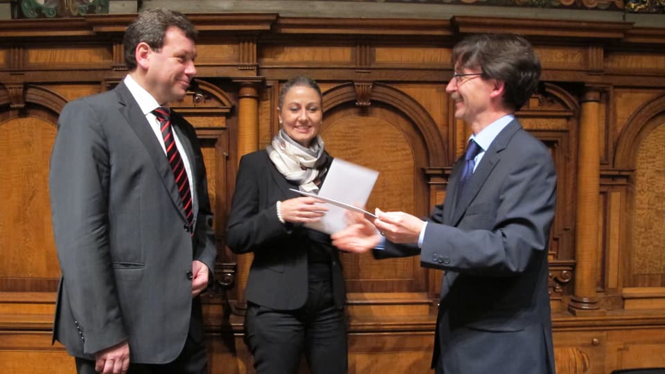 Ratspräsident Raphaël Rohner schüttelt den abtretenden Stadträten Peter Käppeler und Jeanette Storrer die Hand.