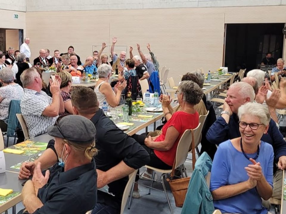 Fröhliches Publikum in einem grossen Saal.