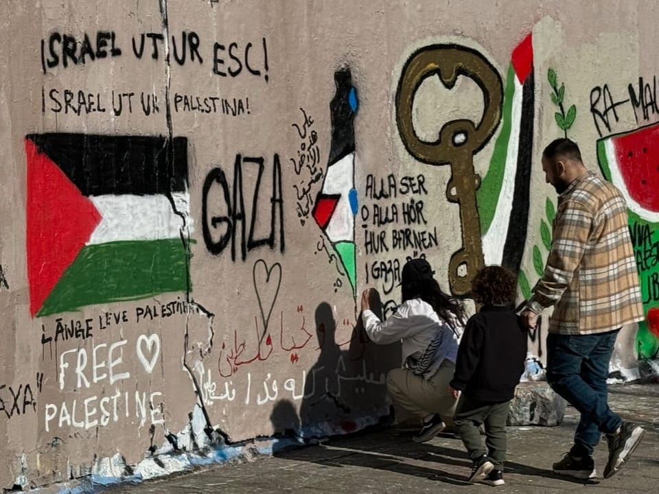 Personen betrachten politische Wandmalerei zum Thema Gaza und Freiheit für Palästina.