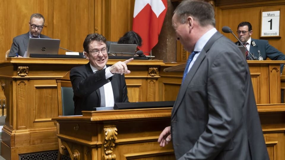 Rösti points his finger at a parliamentarian standing in front of him.