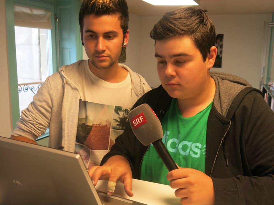 Zwei Jugendliche vor einem Computer. 