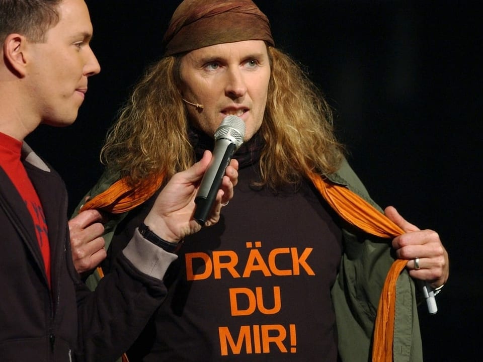 Chris von Rohr und Sven Epiney im Interview. Von Rohr trägt ein T-Shir mit der Aufschrift: Dräck Du mir.