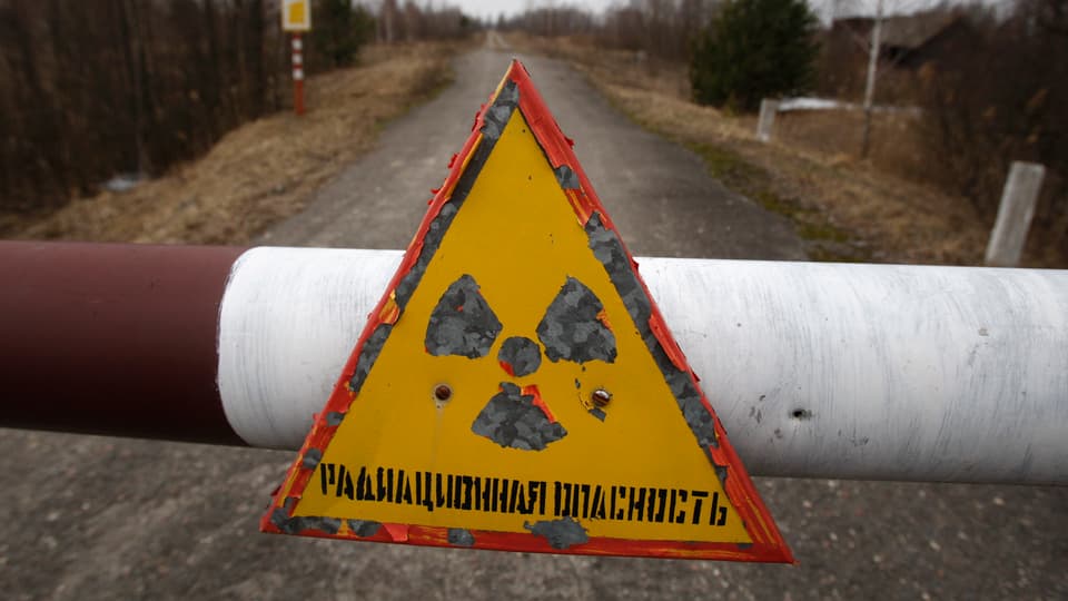 Eine Absperrung mit dem Symbol für Radioaktivität am Rande der Sperrzone in Tschernobyl.
