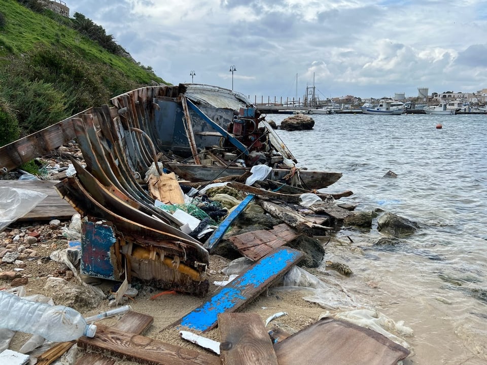 Ein kaputtes Boot an einer Bucht in Lampedusa