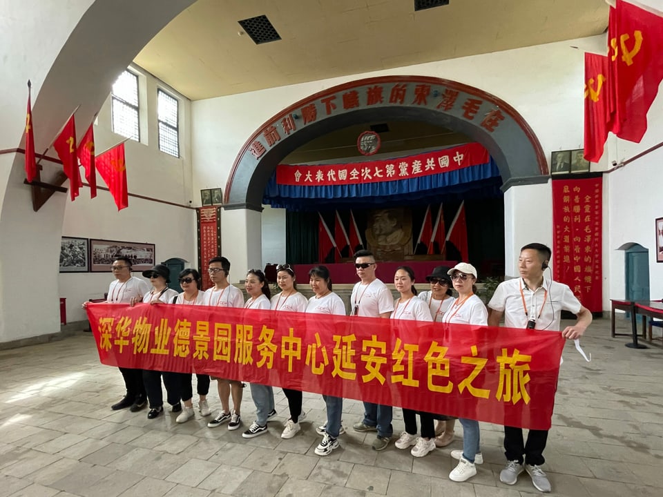 Angestellte auf einem Firmenausflug posieren in der Halle des Parteikongresses