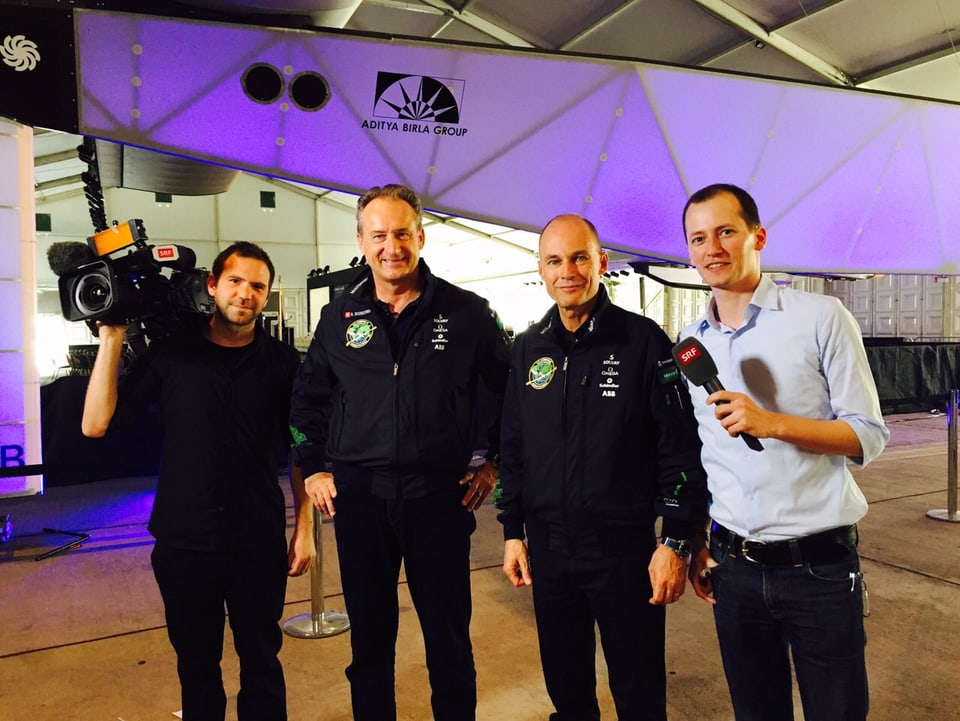 Ein Team von Journalisten und Piloten stellt sich vor einem Flugzeug fürs Foto auf.