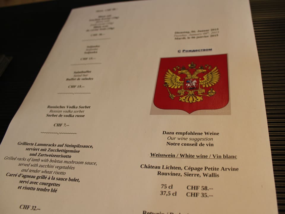Eine Speisekarte mit Menü, russischem Wappen und Weinvorschlägen.