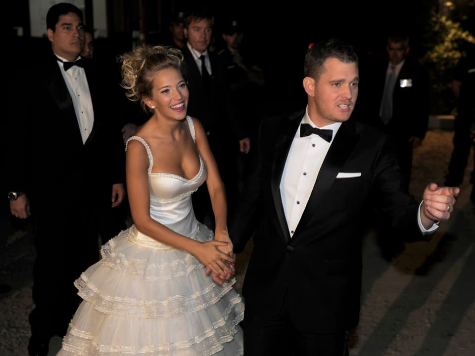 Blonde Frau in weissem Hochzeitskleid mit Mann in schwarzem Anzug