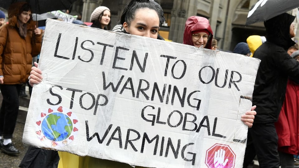 Ein Jugendliche fordert an einer Demonstration einen besseren Klimaschutz