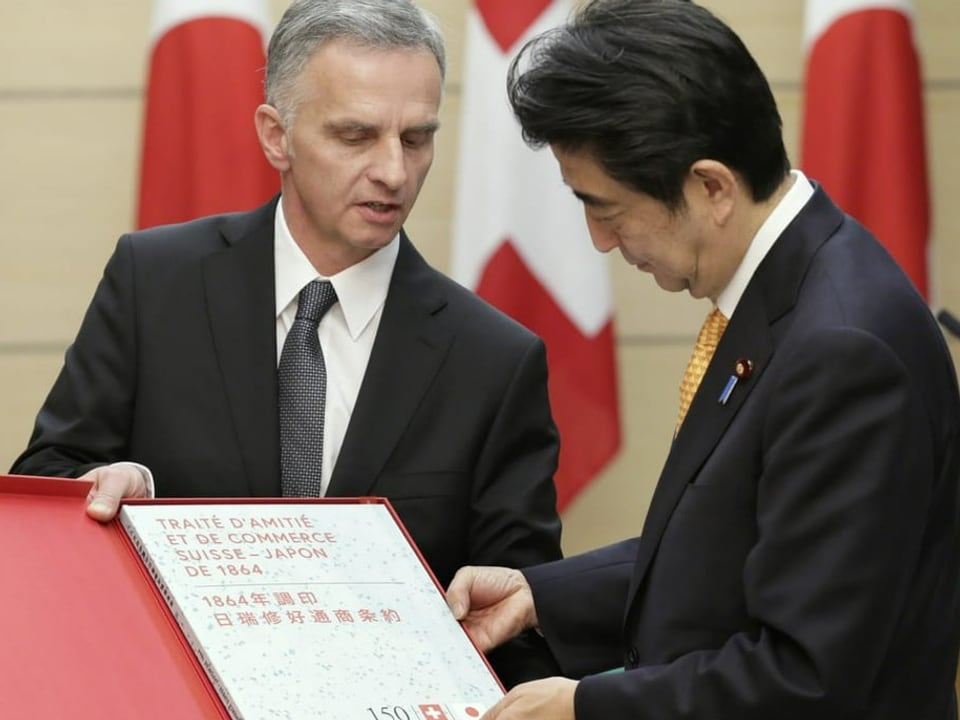Der damalige Bundespräsident Didier Burkhalter gibt Shinzo Abe eine Nachbildung des Freundschafts- und Handelsvertrags. 