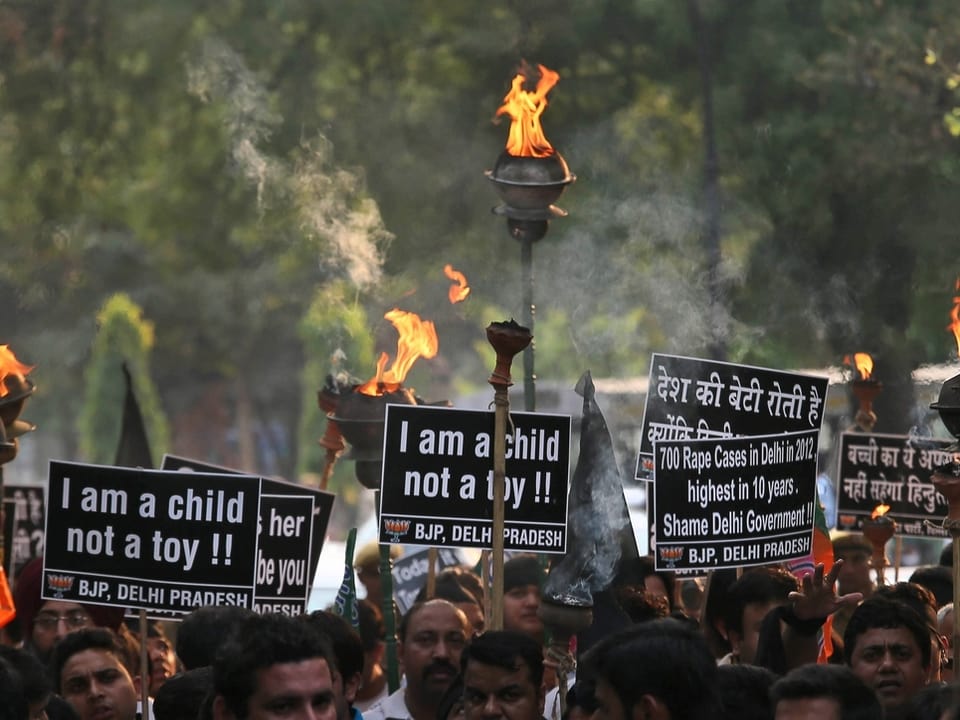 Demonstranten halten Fackeln und Plakate in die Höhe, auf denen steht: «Ich bin ein Kind, kein Spielzeug!»