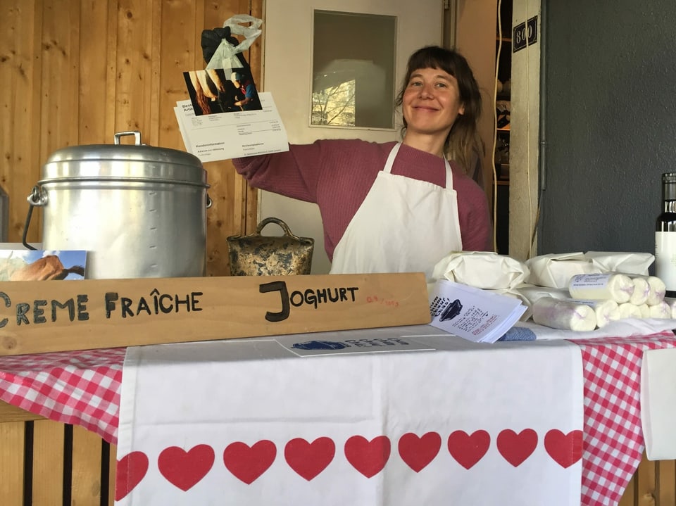 Käseproduzentin Rona Diem steht in ihrem improvisierten Marktstand für die Abholung ihrer bestellten Ware bereit.