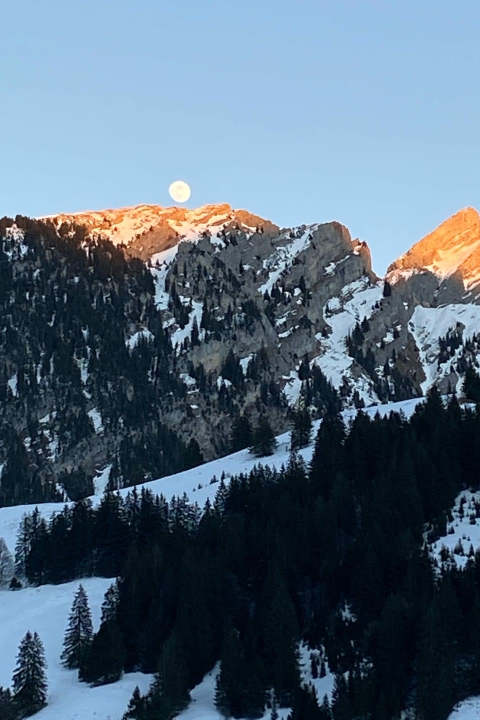 Der Mond scheint über den Bergen.