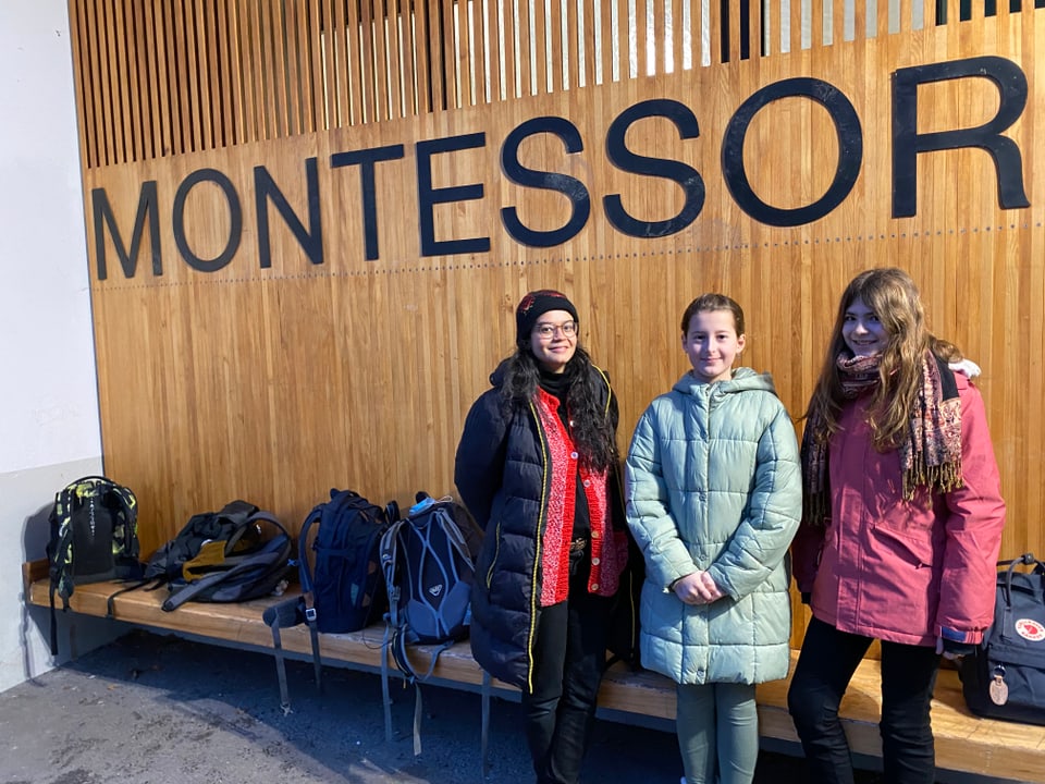 Kinderreporterin Gioanna, Reporterin Julia und Mia stehen vor der Montessori Schule in Luzern. 