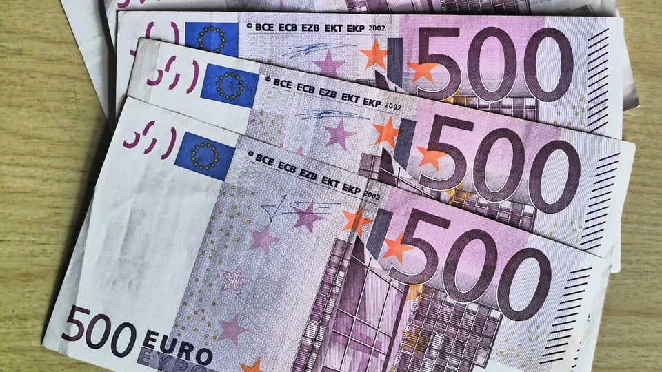 Aufgefächerte 500-Euro-Banknoten auf dem Tisch.