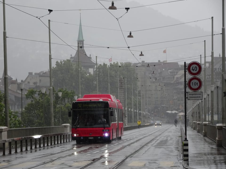 Ein Bus fährt über die Brücke, Regen.