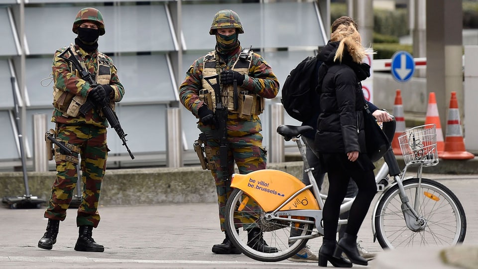 Zwei bewaffnete Militaristen bewachen nach den Anschlägen in Brüssel ein Gebäude. 