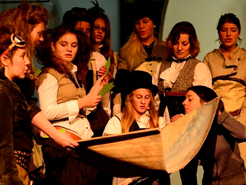 Szene aus eineme Theater: Eine Gruppe von Mädchen schaut eine Seekarte an.