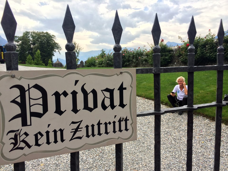 Alexandra Felder sitzt telefonierend hinter einem Zaun, auf dem ein Schild mit dem Vermerk «Privat» steht.