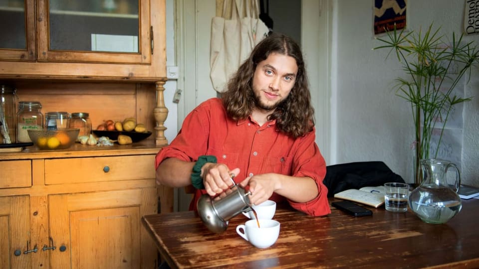 Eine Person schenkt aus einer Kanne Kaffee ein.