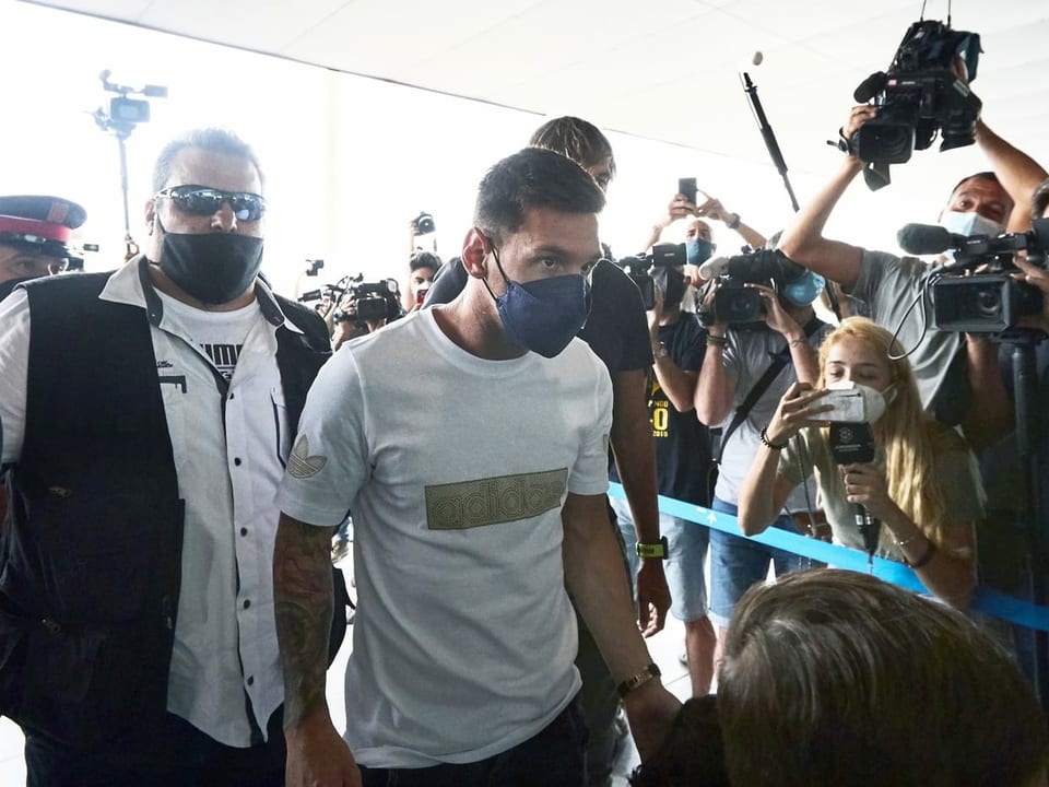 Lionel Messi am Flughafen Barcelona umringt von Fans.
