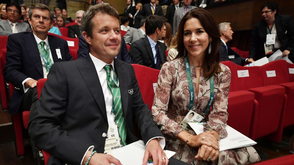 Kronprinzessin Mary und Kronprinz Frederik aus Dänemark sitzen nebeneinander und lächeln in die Kamera. 