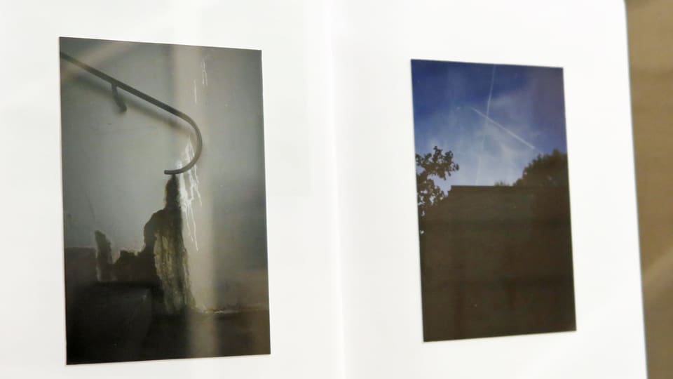 Ein weisses Buch mit zwei Fotos darin.