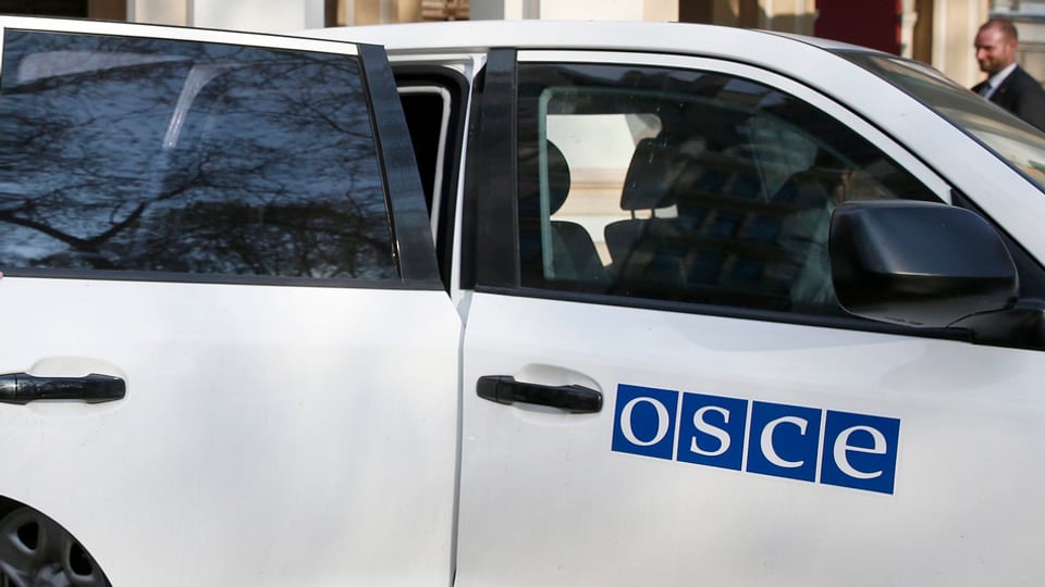 Weisses Auto der OSZE mit Schriftzug der Organisation auf der Vordertüre